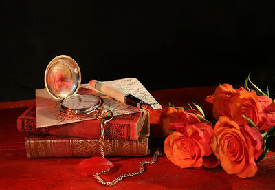 Close-up of red rose on table against black background