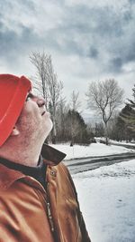 Man standing on snow covered field against sky