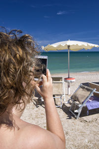 Woman using mobile phone at beach