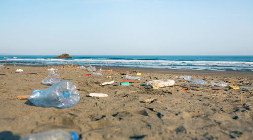 Surface level of garbage on beach against clear sky