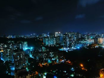 Illuminated cityscape against sky at night