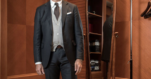 Stylish man in suit in wardrobe