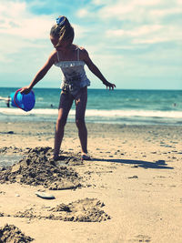 Full length of boy on beach against sky