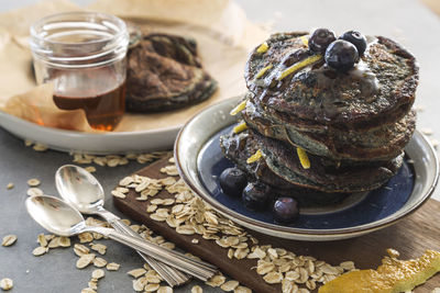 High angle view of pancakes with blueberries and oats on table