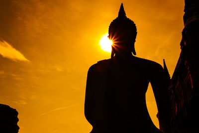 Low angle view of silhouette statue against sky during sunset