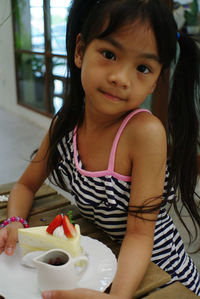 Portrait of cute girl with ice cream on table