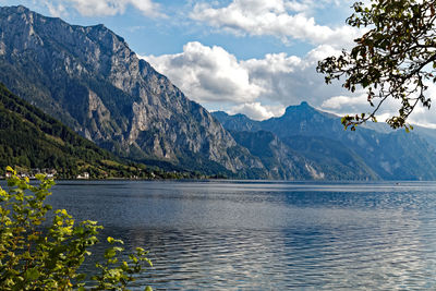 Scenic view of lake by mountains against sky