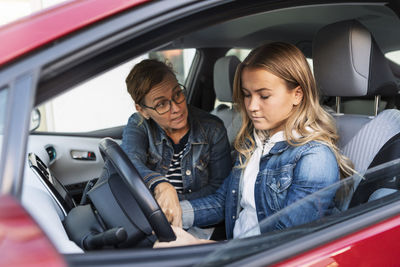 Mother teaching teenager driving during weekend