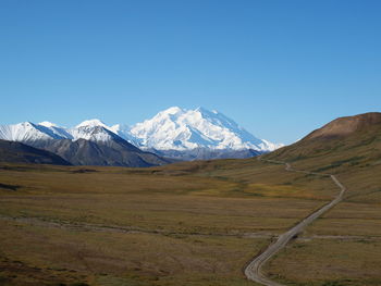 Scenic view of snowcapped mountains against clear blue sky