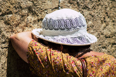 Rear view of woman wearing hat on rock