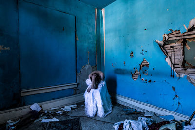 High angle view of woman sitting in abandoned house