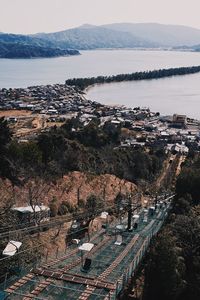 High angle view of townscape by sea against sky