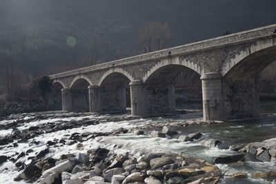 Arch bridge over river during winter