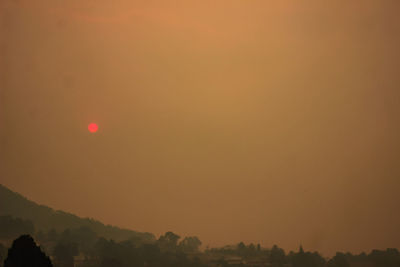 Scenic view of silhouette mountains against orange sky