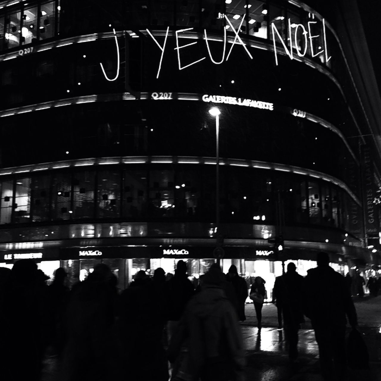 illuminated, night, text, architecture, city, building exterior, built structure, communication, large group of people, city life, western script, transportation, street, men, non-western script, city street, person, information sign, travel