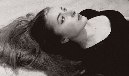 Close-up portrait of young woman lying down