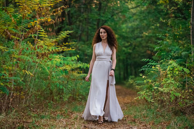 Full length of woman standing in forest