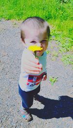 High angle view of cute boy holding footpath