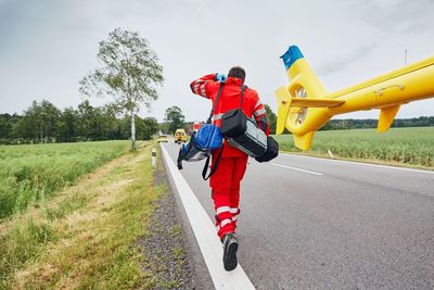 Man with bags walking on road against sky