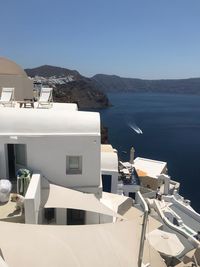 Built structure by sea against clear blue sky