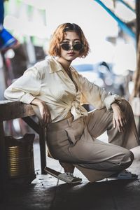 Young woman sitting on table in city