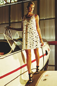 Full length portrait of woman standing by airplane