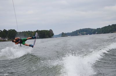 Man surfing in sea against sky