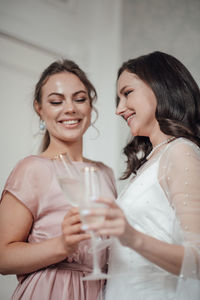 Portrait of a smiling young woman drinking glass