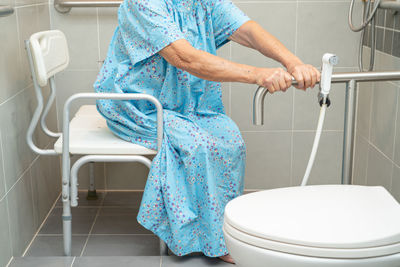 Low section of woman standing in bathroom