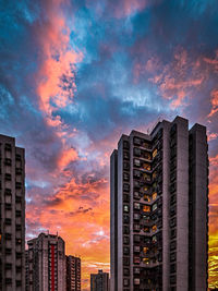 Low angle view of modern buildings against sky during sunset