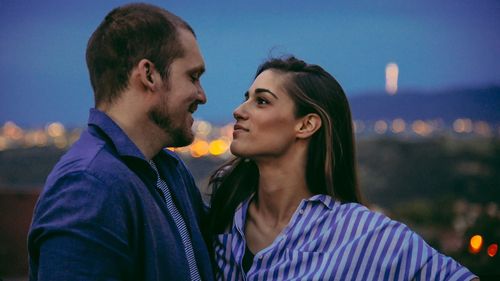 Portrait of couple kissing against sky