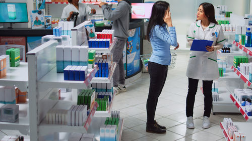 Rear view of female friends standing in store