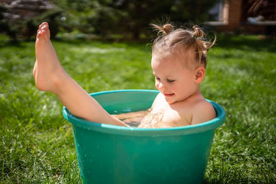 Side view of boy playing in bathtub