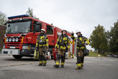 Firefighters walking, fire engine in background