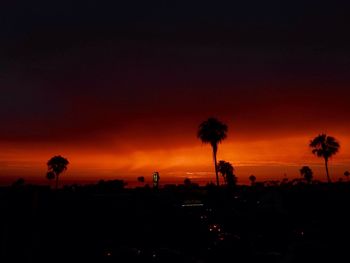 Silhouette trees on landscape against romantic sky at sunset