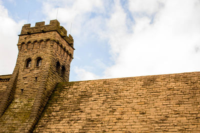 Low angle view of old building against cloudy sky