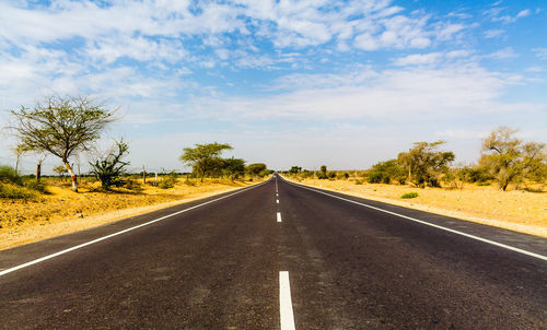 Road passing through landscape against sky