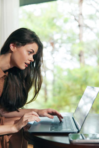 Young businesswoman using laptop at office