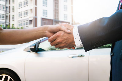 Midsection of couple holding hands