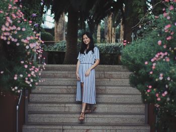 Portrait of young woman standing on stairs