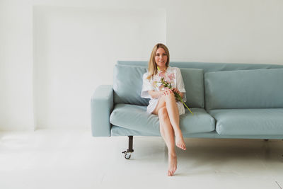 Portrait of woman sitting on sofa at home