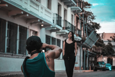 Rear view of man standing on street in city