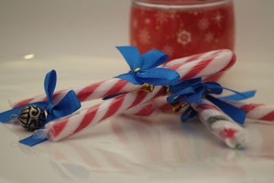 Close-up of candy canes with blue ribbons on table