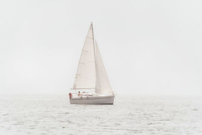 Sailboat sailing on sea against sky