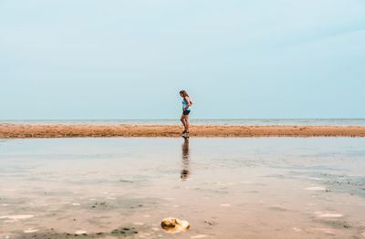 Man standing on beach against sky