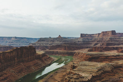 View of rock formations on landscape against cloudy sky