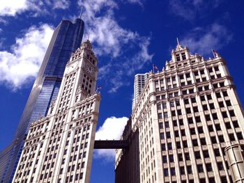 Low angle view of skyscrapers against cloudy sky