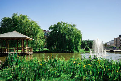 Scenic view of lake by building against clear sky