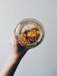 Close-up of hand holding glass of jar