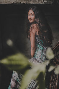 Portrait of beautiful woman standing on staircase in abandoned building